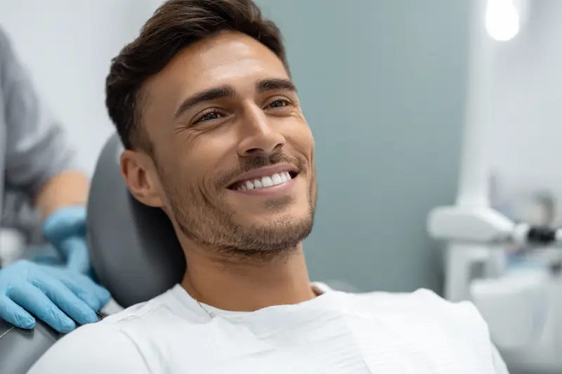 Paciente tranquilo en la silla odontológica mientras el especialista le explica el procedimiento antes de una endodoncia