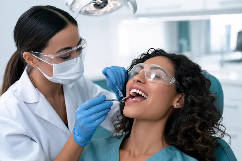 Rehabilitador oral examina los dientes de una paciente para establecer su diagnóstico